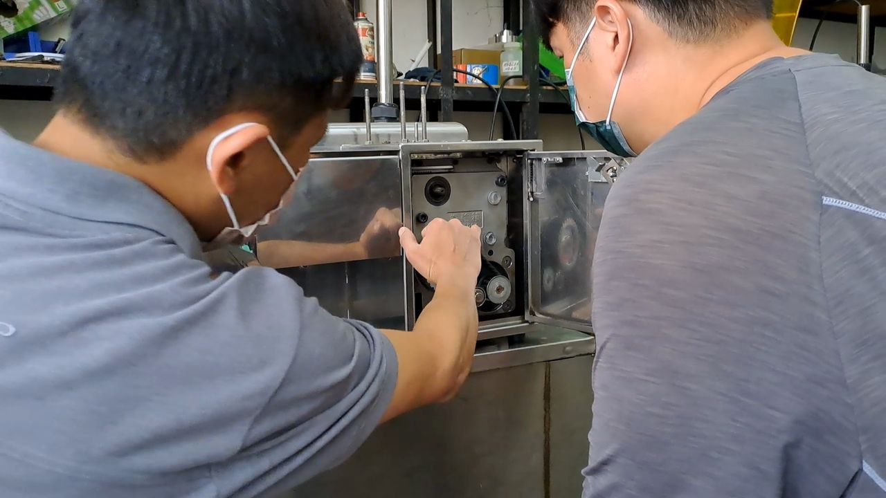 兩位師傅一起檢查機台，討論組裝細節